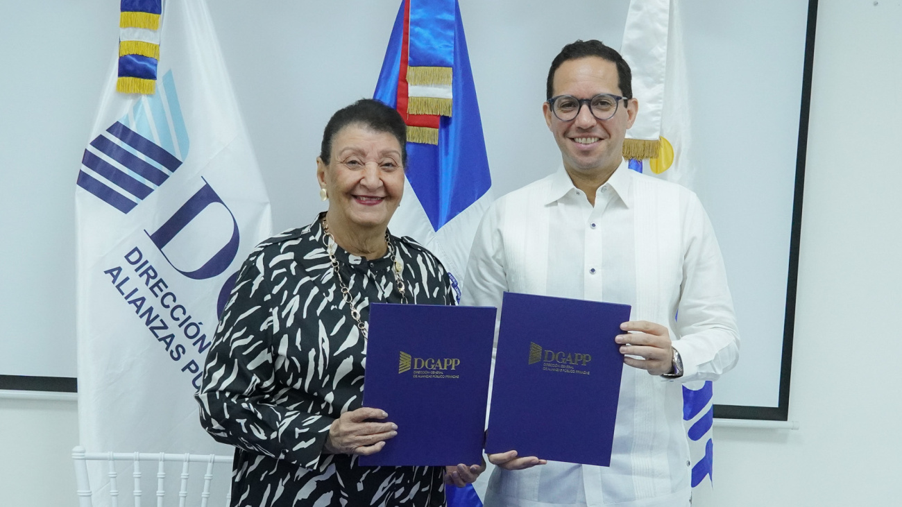 Los directores de INAIPI y DGAPP, Besaida Manola Santana y Sigmund Freund posan con la carpeta del convenio firmado.